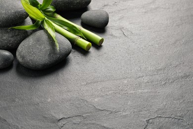 Spa stones and bamboo stems on grey table. Space for text