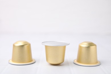 Coffee capsules on white tiled table, closeup