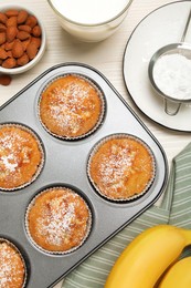 Photo of Flat lay composition with homemade banana muffins and milk on white wooden table