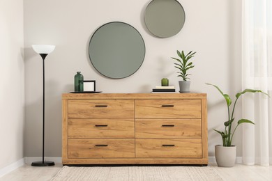 Photo of Cozy room interior with chest of drawers, mirrors and decor elements