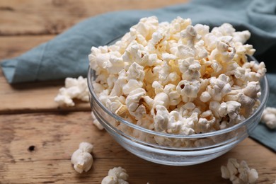 Photo of Tasty popcorn on wooden table, closeup view