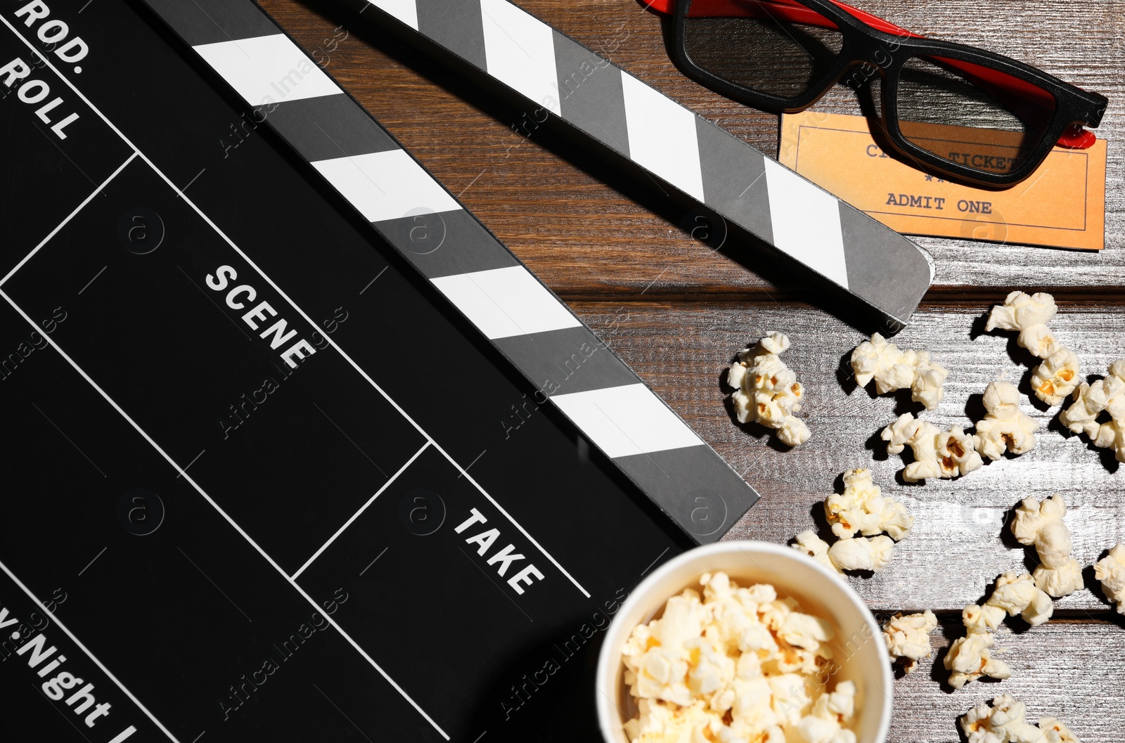 Photo of Flat lay composition with clapperboard and popcorn on wooden table