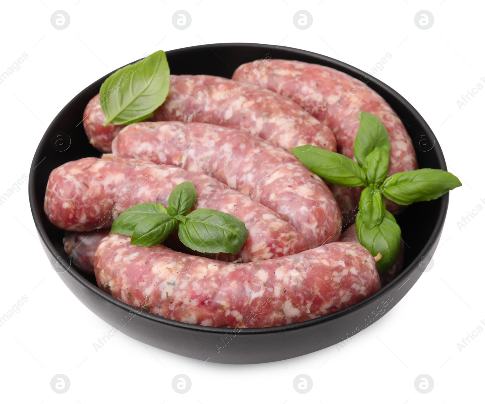 Photo of Raw homemade sausages and basil leaves in bowl isolated on white
