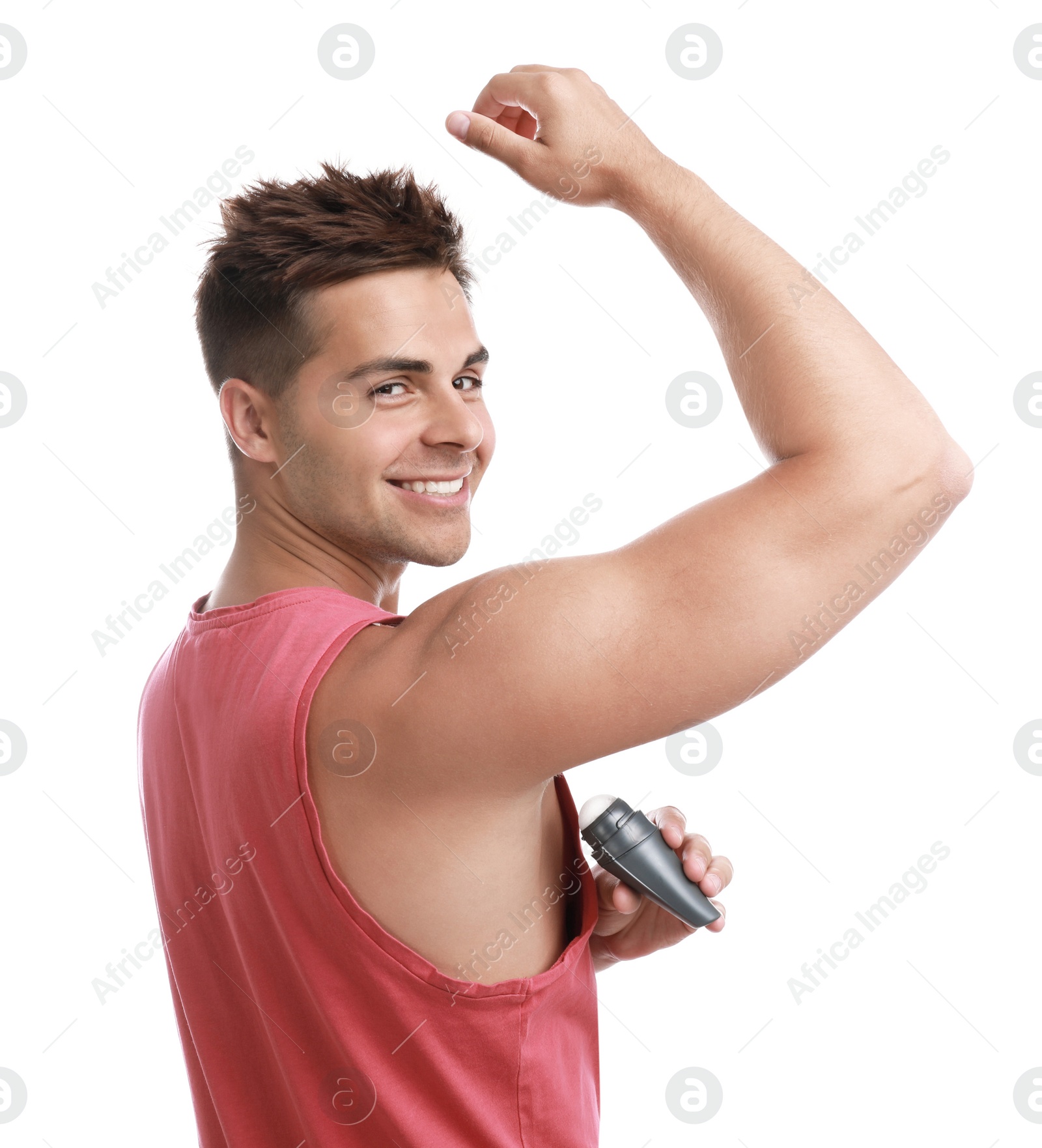 Photo of Young man applying deodorant to armpit on white background