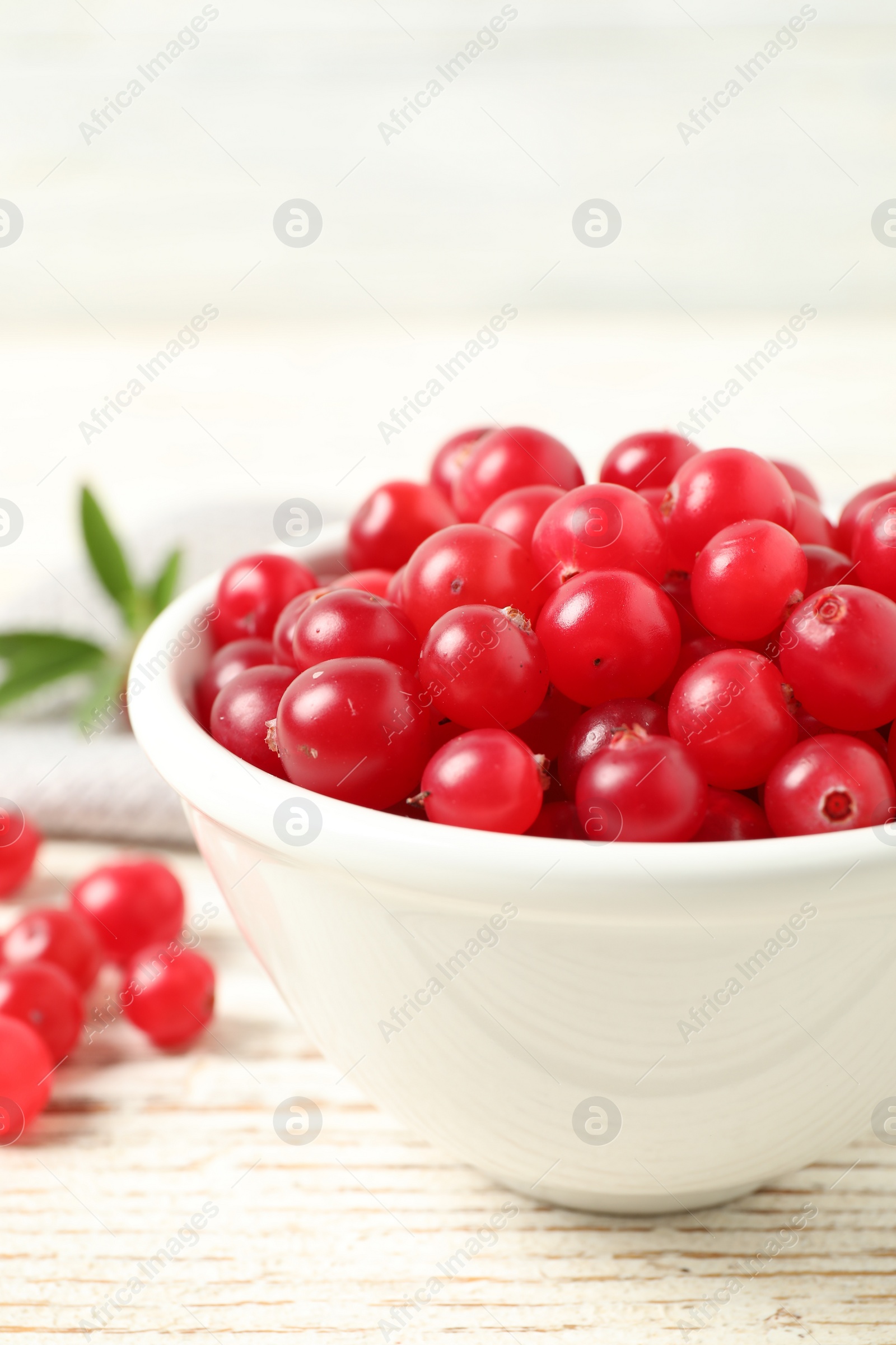 Photo of Tasty ripe cranberries on white wooden table, closeup