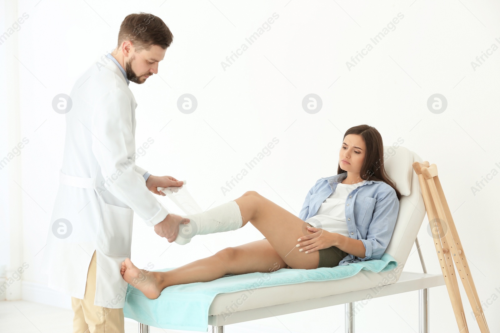 Photo of Doctor putting patient's leg in plaster  at clinic