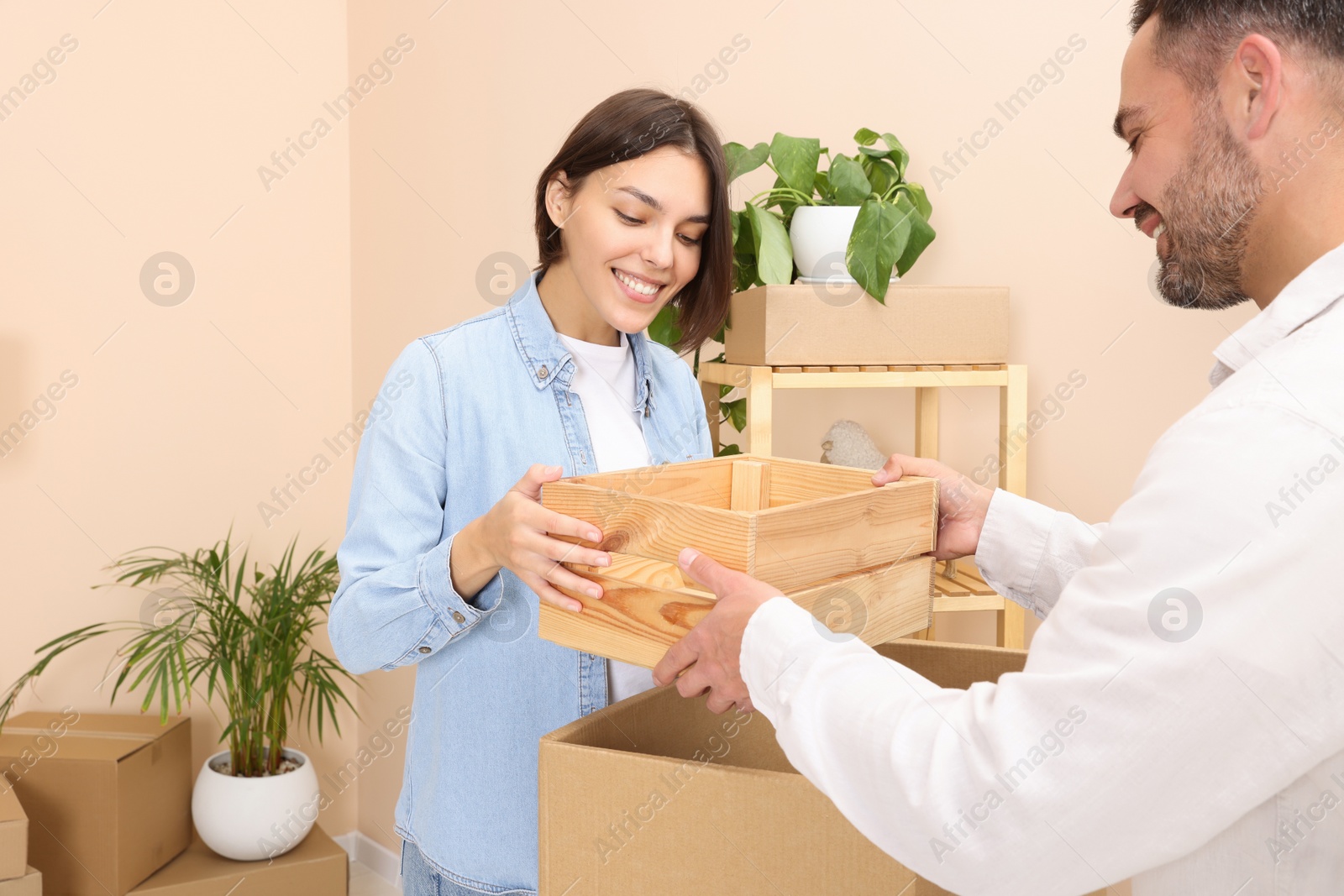 Photo of Happy couple unpacking box in new apartment. Moving day