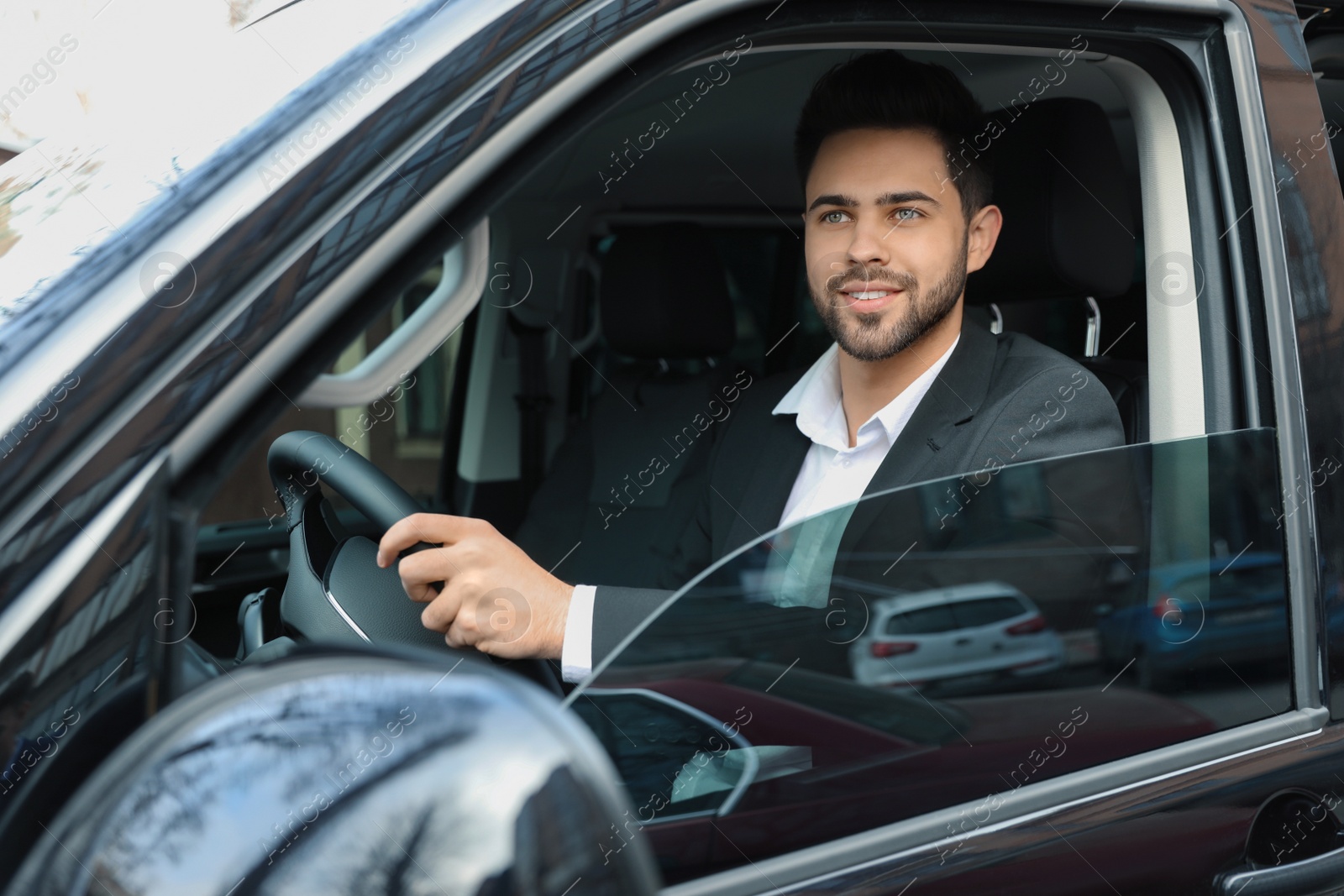 Photo of Handsome young man driving his modern car