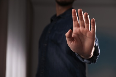 Photo of Man offering helping hand on blurred background, closeup. Space for text