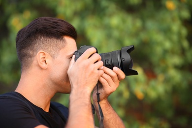 Photographer taking picture with professional camera in countryside