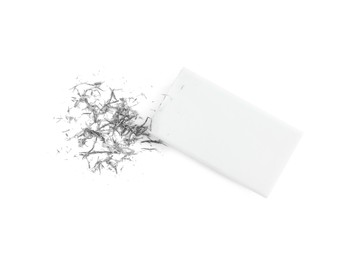 Photo of Eraser and grey crumbs on white background, top view