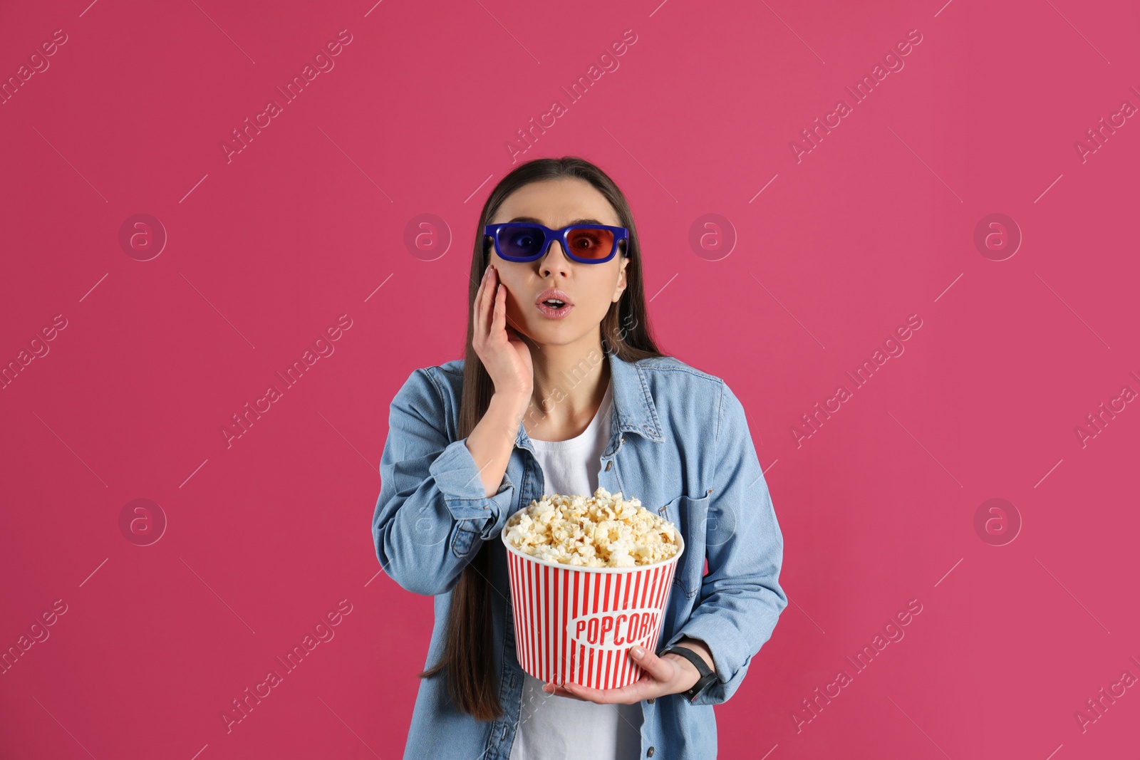 Photo of Emotional woman with 3D glasses and tasty popcorn on color background