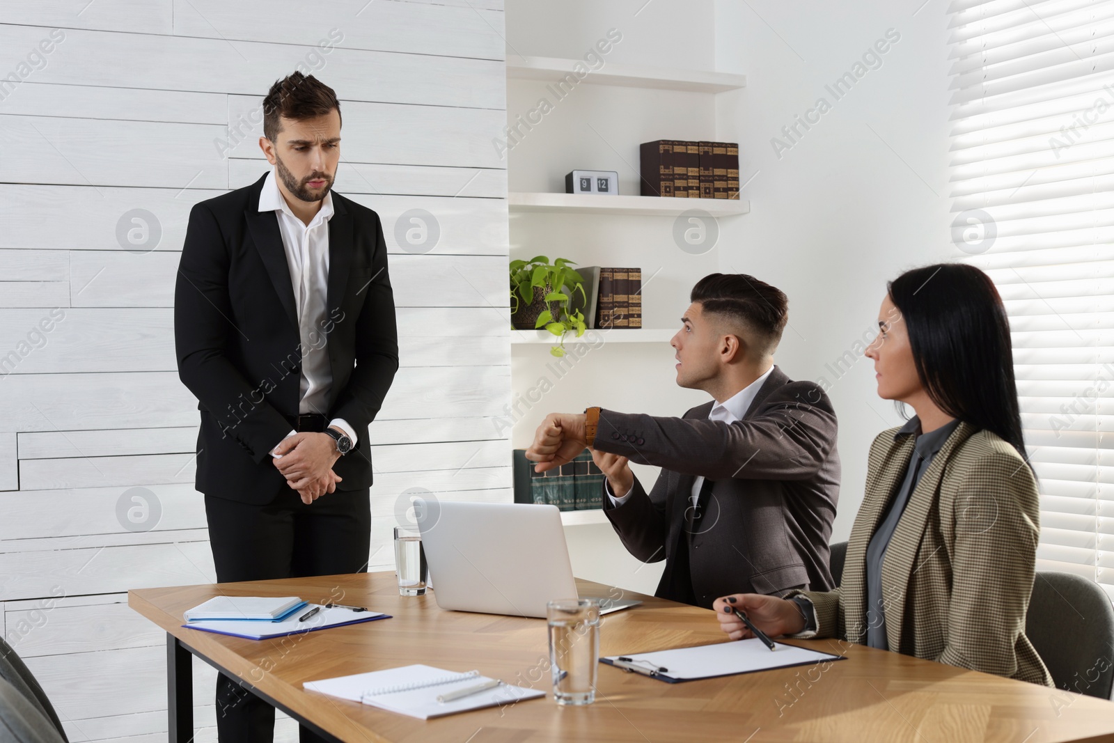 Photo of Businessman scolding employee for being late on meeting in office