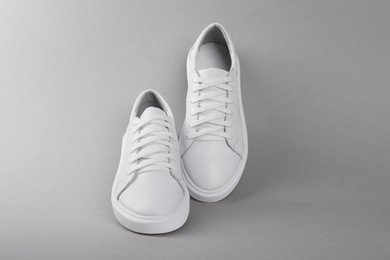 Photo of Pair of stylish white sneakers on grey background