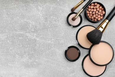 Flat lay composition with makeup brushes on grey stone table, space for text
