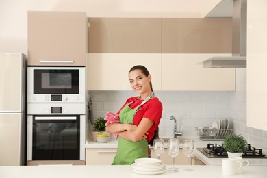 Photo of Beautiful young woman with clean dishes in kitchen