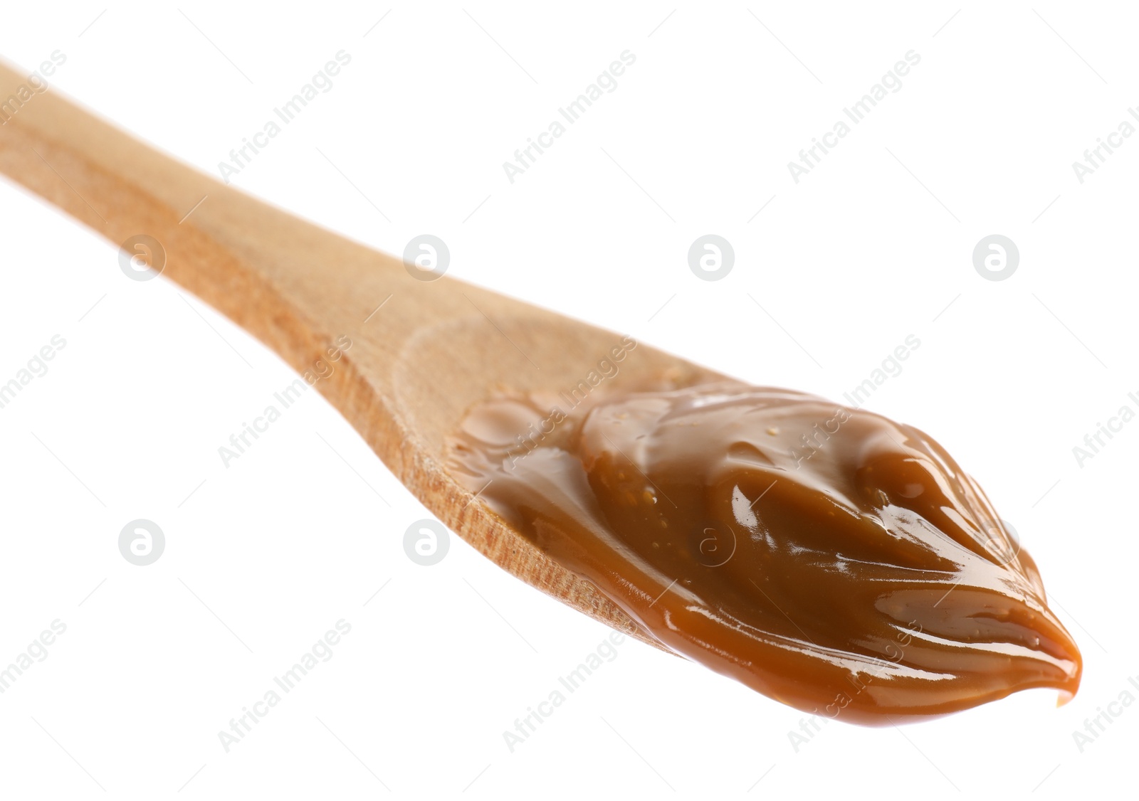 Photo of Wooden spoon with tasty boiled condensed milk isolated on white