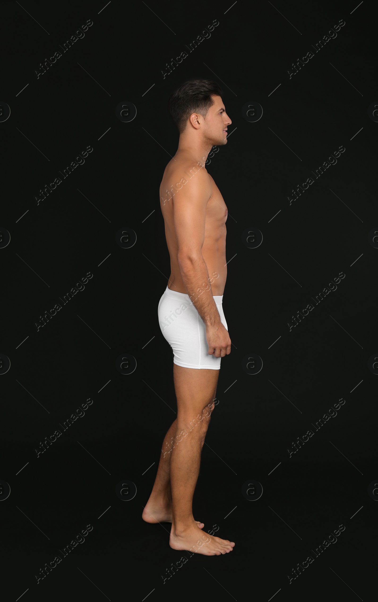 Photo of Handsome man in underwear on black background