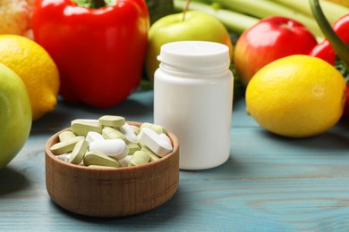 Photo of Dietary supplements. Blank white bottle and bowl with different pills near food products on light blue wooden table, closeup