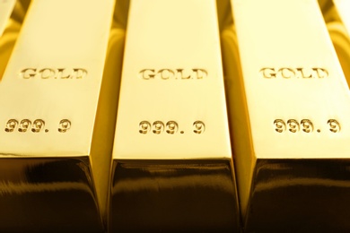 Photo of Shiny sleek gold bars as background, closeup
