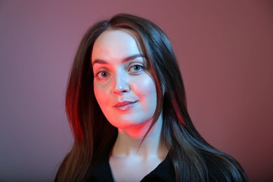 Photo of Portrait of beautiful young woman on color background with neon lights