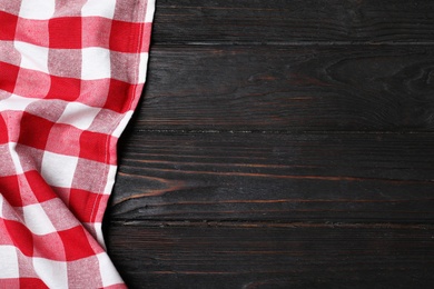 Checkered picnic blanket on color wooden background, top view. Space for text