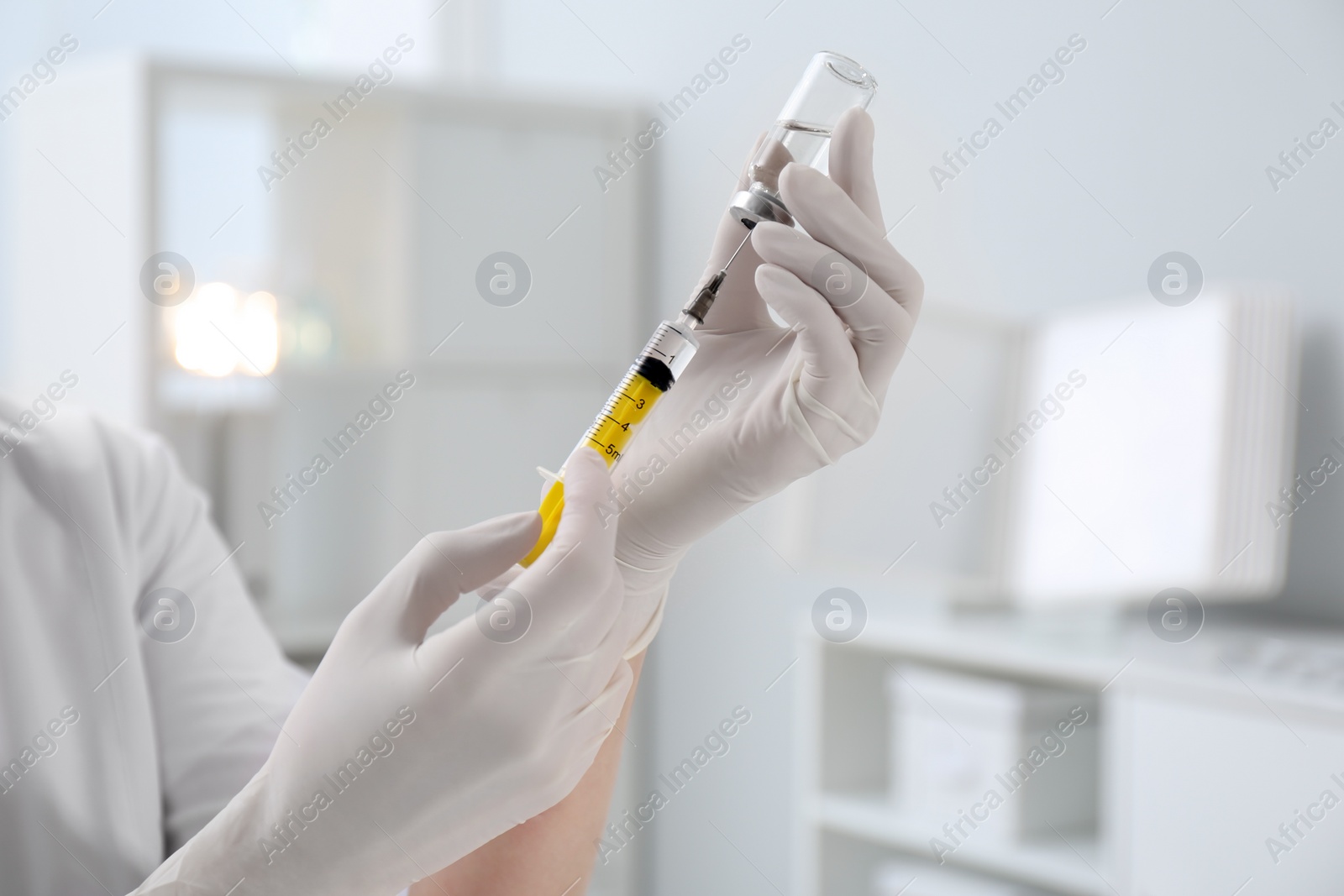 Photo of Doctor filling syringe with medication from vial in hospital, closeup