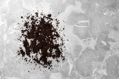Scattered coffee grounds on marble table, top view. Space for text