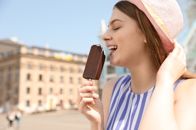 Young happy woman eating ice cream in amusement park