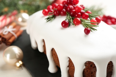 Photo of Traditional classic Christmas cake decorated with cranberries and rosemary on table, closeup