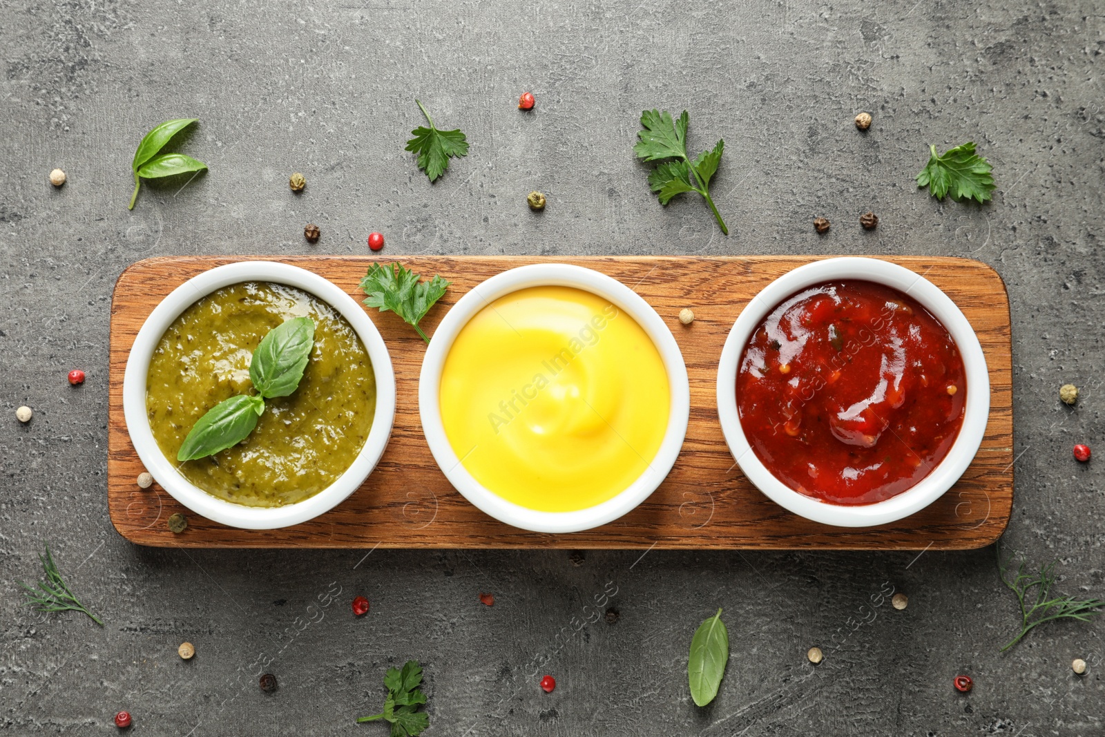 Photo of Set of different delicious sauces on grey table, top view