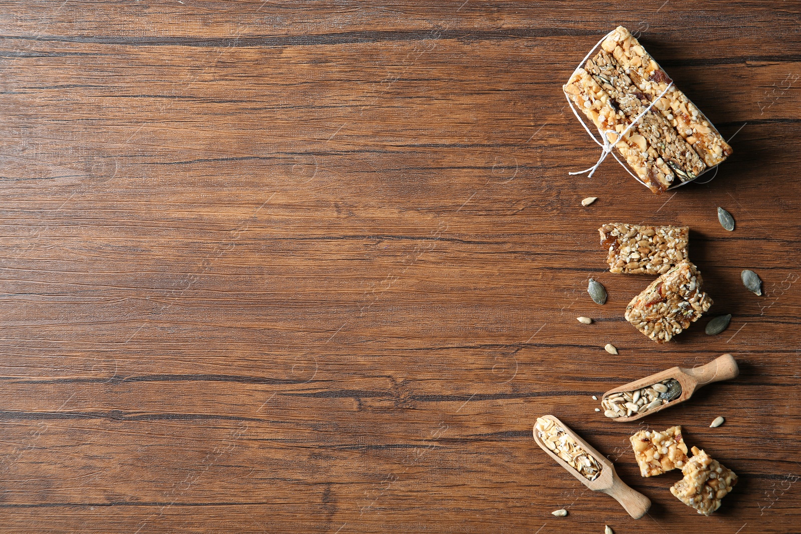 Photo of Flat lay composition with cereal bars on wooden background. Whole grain snack