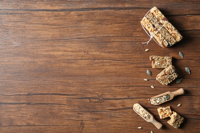 Flat lay composition with cereal bars on wooden background. Whole grain snack