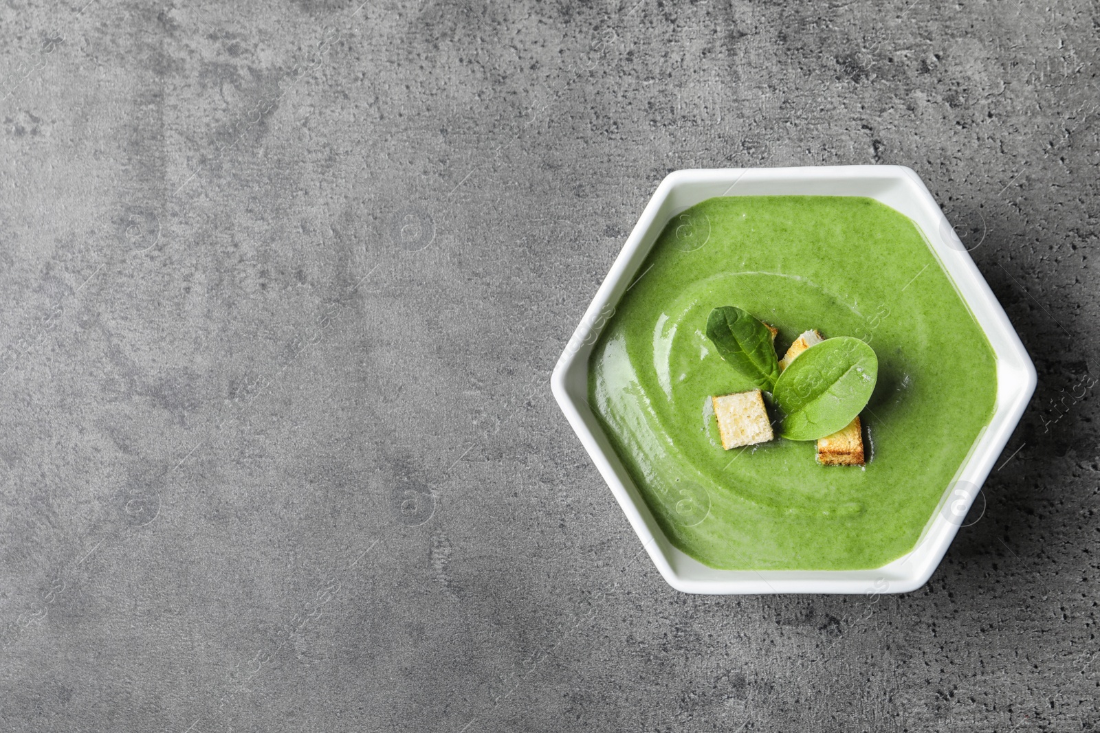 Photo of Fresh vegetable detox soup made of spinach in dish on table, top view with space for text