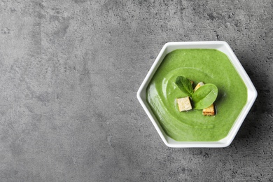 Photo of Fresh vegetable detox soup made of spinach in dish on table, top view with space for text