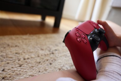 Photo of Child playing video games with controller at home, closeup. Space for text