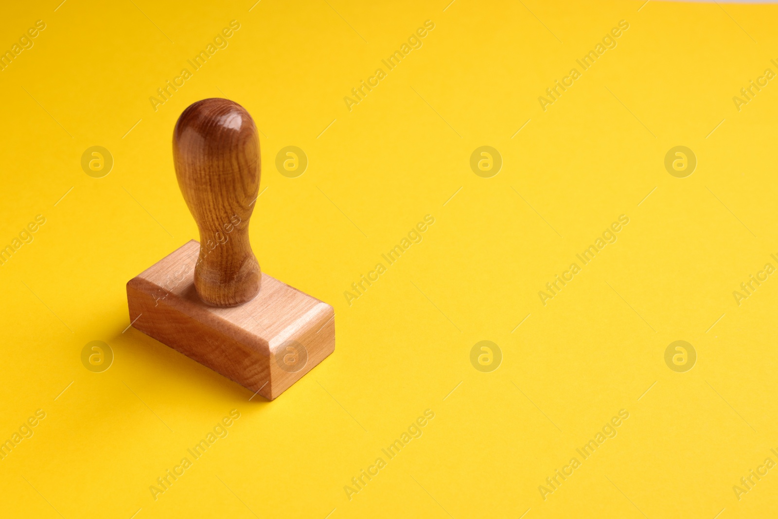 Photo of One wooden stamp tool on yellow background, space for text