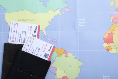 Photo of Passports with tickets on world map, flat lay. Travel agency concept