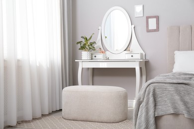 Photo of Elegant dressing table with mirror near window in bedroom