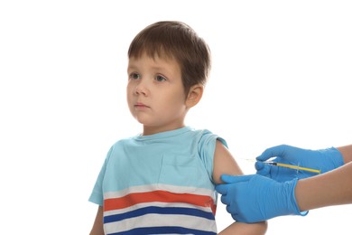 Doctor vaccinating little boy on white background