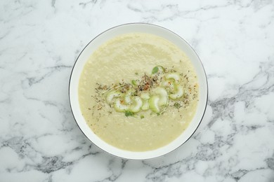 Photo of Bowl of delicious celery soup on white marble table, top view