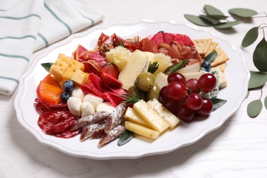Photo of Tasty assorted appetizers served on white wooden table