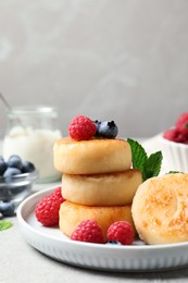 Delicious cottage cheese pancakes with berries on light table