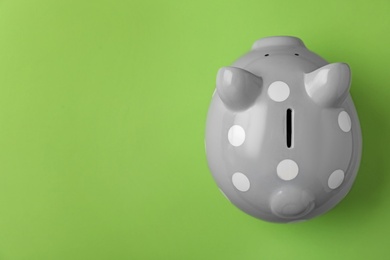 Photo of Gray piggy bank on color background, top view