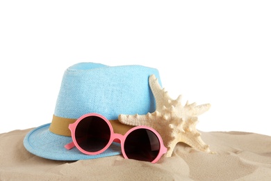 Beach accessories on sand against white background