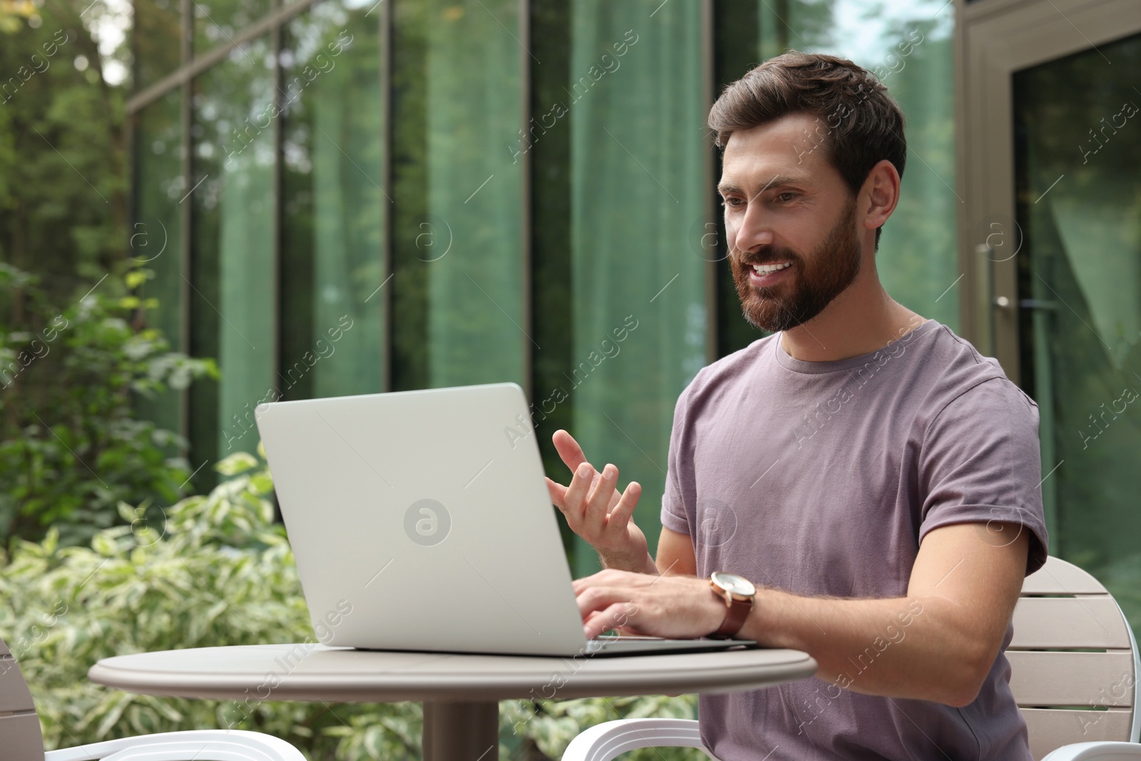 Photo of Handsome man with laptop in outdoor cafe