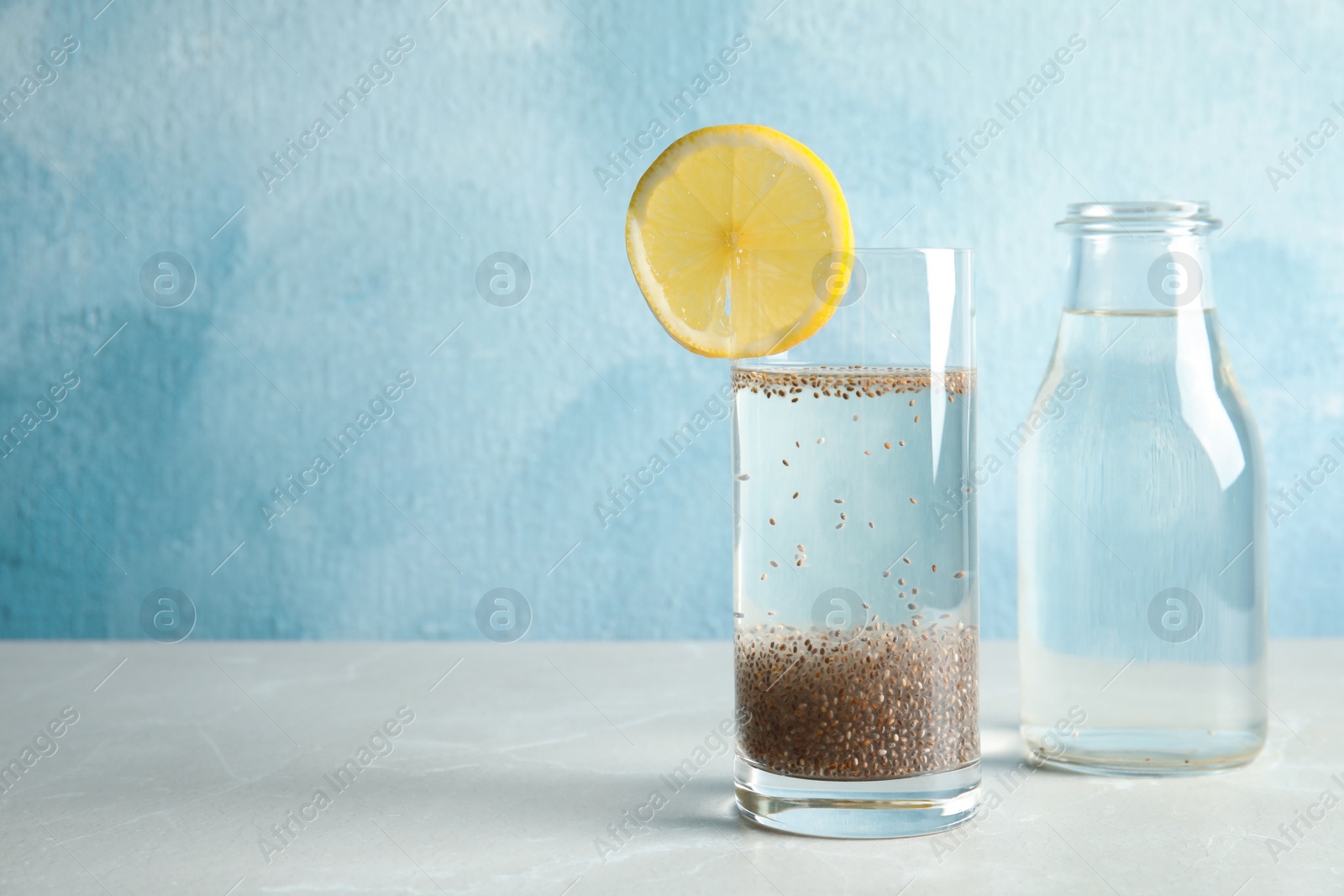 Photo of Composition with water and chia seeds on table against color background, space for text