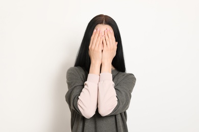 Photo of Upset young woman crying against white background