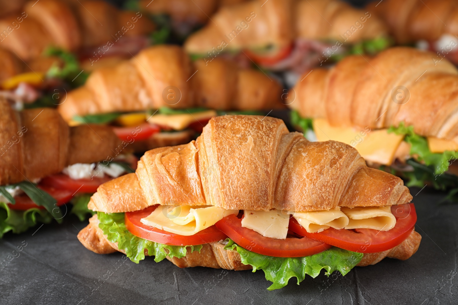 Photo of Tasty croissant sandwiches on grey table, closeup