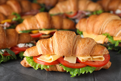 Photo of Tasty croissant sandwiches on grey table, closeup